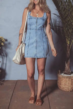 Light blue denim dress with square neck wide straps and front zipper in a mini skirt style