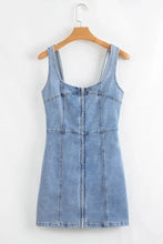 Light blue denim dress with square neck wide straps and a front zipper in a mini length design