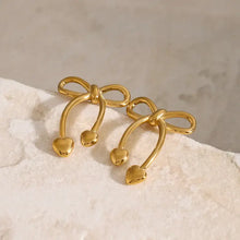 Pair of gold stainless steel bow earrings with heart-shaped drops