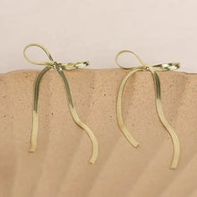 Gold stainless steel bow earrings with long wavy chain dangles