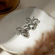 Silver-toned stainless steel bow heart drop earrings with minimalist design