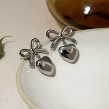 Silver-toned stainless steel bow heart drop earrings with bow details