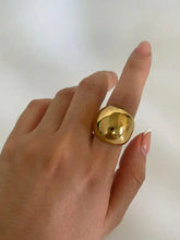 Shiny stainless steel bubble statement ring with gold dome on hand