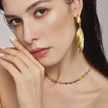 Woman in 18k gold-plated stainless steel dangle earrings and floral choker