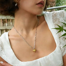 Woman in white lace top wearing stainless steel heart pendant on 18k gold-plated chain