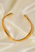 Gold stainless steel open bracelet with twisted fluid design