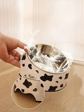 Stainless steel pet bowl with black and white cow print exterior