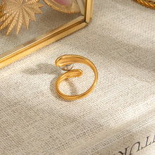 Stainless steel twisted ring with gold swirl, silver sphere, and clear gemstone