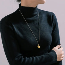 Black long-sleeved turtleneck with 18k gold-plated steel water drop pendant necklace