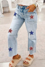 Light-wash denim cropped jeans with red and blue sequined star embellishments on the legs