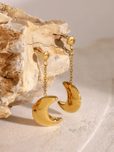 Brincos pendentes em aço dourado com detalhes em pérola e gotas de corrente