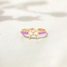 Sterling silver bow ring with rose gold accents and purple gemstones