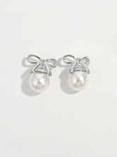 Elegant sterling silver pearl bow earrings with silver accents