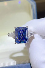 Sterling silver ring with blue radiant gemstone and trillion side stones