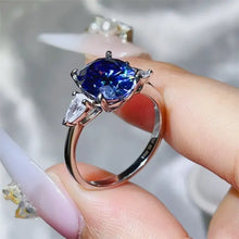 Sterling silver ring with cushion-cut blue sapphire and pear moissanite side stones