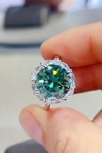 Sterling silver ring with oval emerald green gemstone and diamond halo