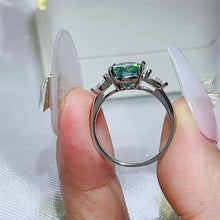 Sterling silver ring with oval teal-green gemstone and baguette moissanite sides