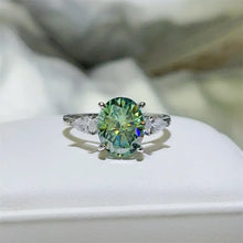 Oval-cut green gemstone sterling silver ring with pear-shaped side stones