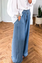 Blue denim chambray wide leg pants with white vertical stripes and a tied elastic waist for comfort and style