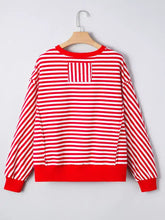 Red and white striped long-sleeved casual holiday sweatshirt with solid red hem cuffs collar and sequin nutcracker patch