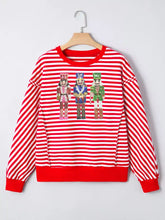 Red and white striped long-sleeved sweatshirt with three sequined nutcracker figures for casual holiday wear
