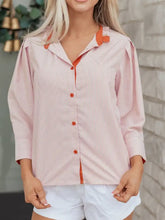 Pink and white vertically striped button-up blouse with orange stripe color block trim and frilled collar button detail