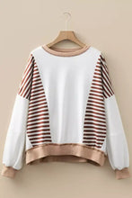 A cozy white and brown striped stripe colorblock patchwork sweatshirt with ribbed beige trim and machine wash cold care instructions