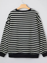 Black and white horizontally striped slightly stretchy long-sleeved sweatshirt with merry letter christmas print and tumble dry care instructions