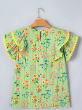A vibrant green stripe floral ruffle short sleeve blouse with yellow sleeves and scalloped edges featuring colorful blossoms