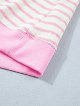 Close-up of pink and white striped ribbed knit sweater cuff on a short sleeve patchwork ruffled short blouse