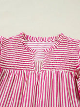 A pink and white vertically striped ruffled short sleeve blouse with smocked neckline and ruffled trim
