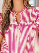 A vibrant pink and white vertically striped ruffled short sleeve blouse with smocked neckline and shirred yoke