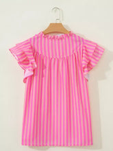 A vibrant pink stripe split neck ruffled summer blouse with vertical stripes and ruffled sleeves on wooden hanger