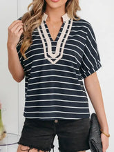 Navy and white horizontally striped short-sleeved blouse with cream embroidered collar v neck and elastic cuffs