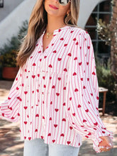 A pink and white blouse with stripe textured heart print, long flounce sleeves, and v-neckline for stylish wear