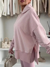 A soft pink and white striped oversized hoodie with thumbhole side slits and drop shoulders machine wash cold