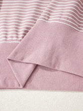 A soft pink and white striped ribbed knit stripe thumbhole side slits drop shoulder loose fit hoodie machine wash cold