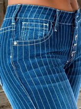 Blue pinstripe denim flare jeans with white stitching and silver decorative buttons feature a striped button fly flare design