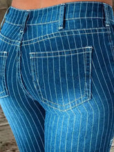 Blue denim flare jeans with white vertical pinstripes and contrasting stitching featuring a striped button fly design