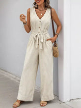 Beige and white striped wide leg jumpsuit with button front and belted waist