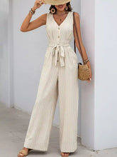 Beige and white striped wide leg jumpsuit with button front and belted waist