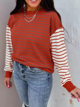 Striped color block long sleeve sweatshirt in rust orange with white and rust stripes made of slightly stretchy material
