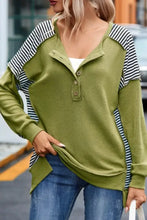 Woman in striped exposed seam half button sweatshirt with jeans