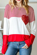 Woman in striped heart sequin long sleeve T-shirt with jeans