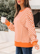 Striped long sleeve casual sweatshirt with orange and white stripes and solid orange hem and cuffs for everyday wear