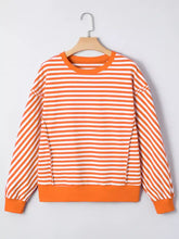 Striped long sleeve casual sweatshirt with orange and white horizontal stripes and solid orange ribbed cuffs hem and neckline