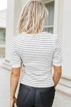 Woman in striped notched short sleeve T-shirt and black pants