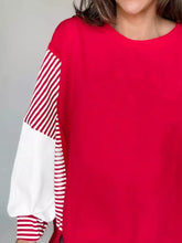 Striped patchwork sleeve colorblock sweatshirt in red with slightly stretchy fabric and machine wash care instructions