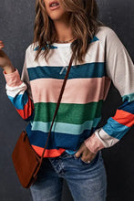 Woman in striped raglan long sleeve top with textured back, jeans, brown bag