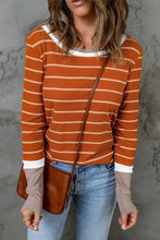 Femme en T-shirt à manches longues rayé à col rond avec jean et sac
